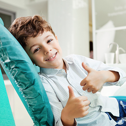 Child giving thumbs up after preventive dental emergencies