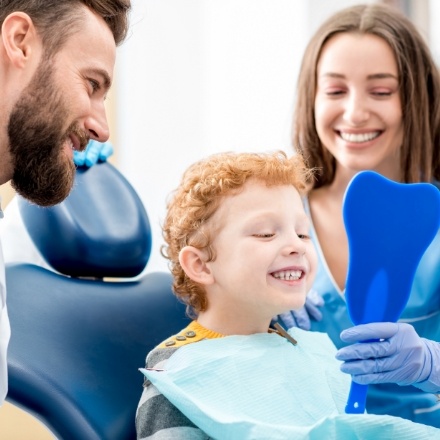 Child looking in mirror during dental checkup and teeth cleaning visit