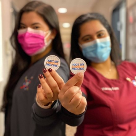 Pediatric dental team members holding their I got my vaccine stickers