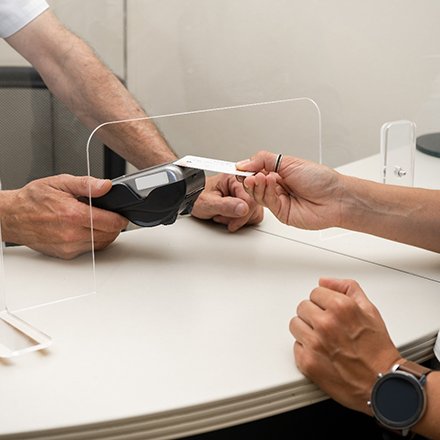 Hand holding out card to device reader for payment