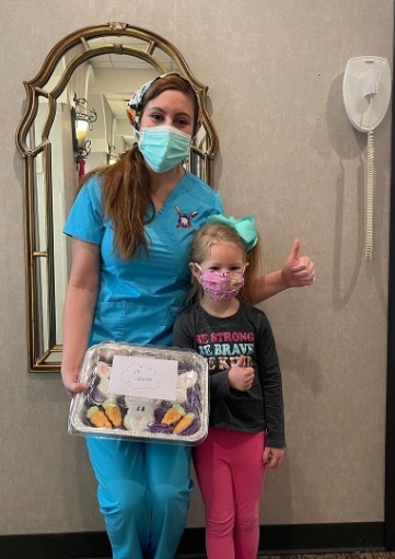 Dentist and patient holding decorated holiday cookies