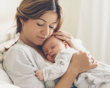 Mother holding baby after treatment for lip and tongue tie