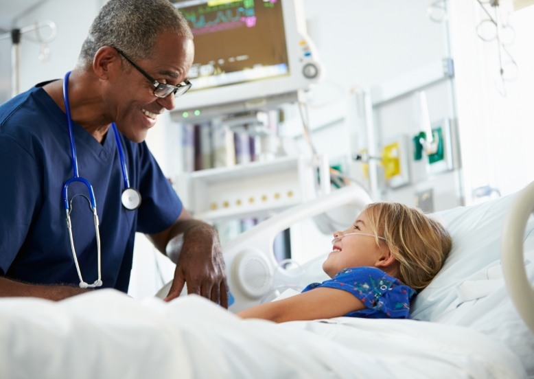 Pediatric dentist talking to young dental patient