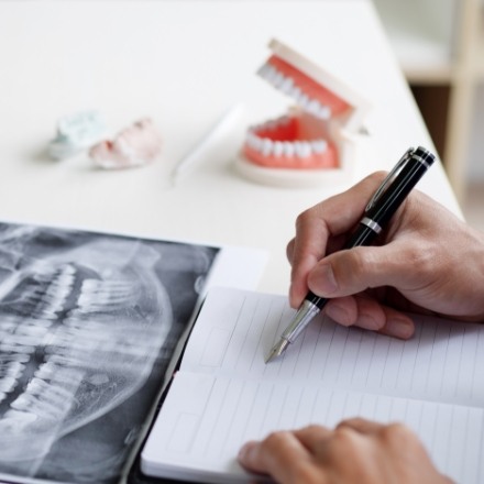 Person with notebook and dental x-rays