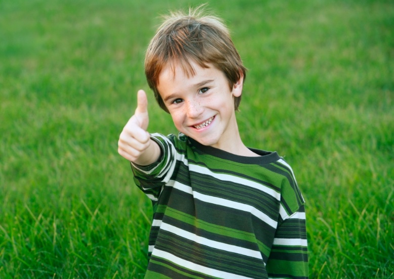 Smiling child giving thumbs up after preventive dentistry visit