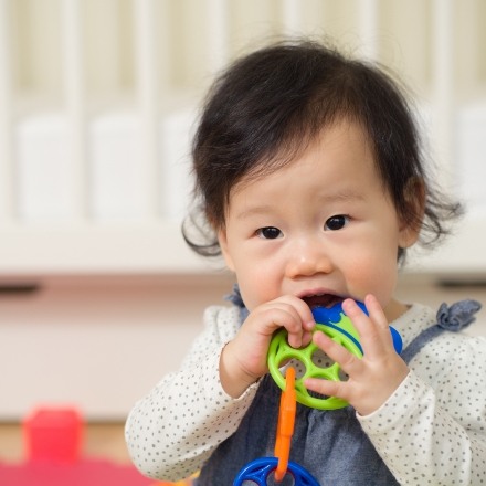 Teething child chewing on a toy