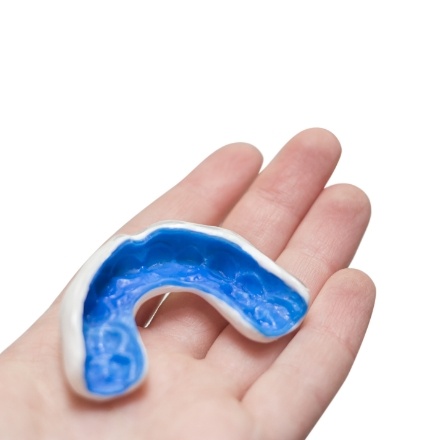 Hand holding a custom athletic mouthguard