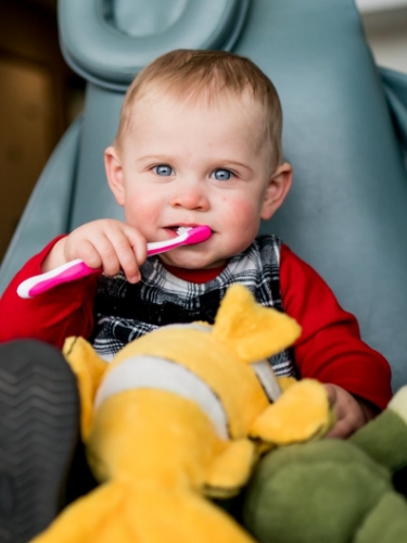 Baby brushing teeth during appointment for pediatric dental services