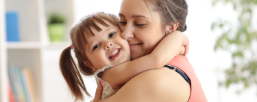 Mother holding child after emergency dentistry visit