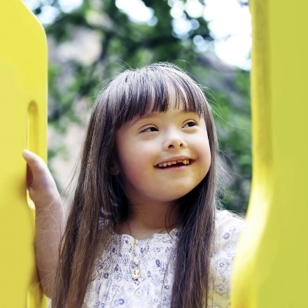 Child smiling outdoors after special needs dentistry
