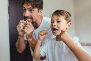 Father and son flossing.